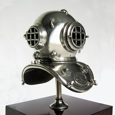 Ornamental silver-coloured diving helmet, mounted on a plinth