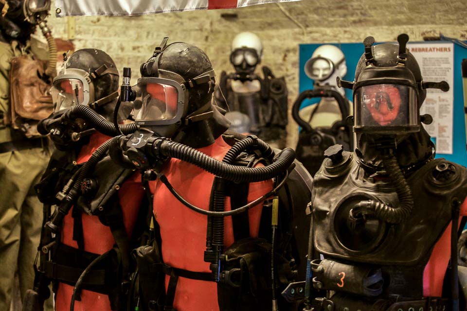 Three military diving sets on three red half mannequins (torso and head)