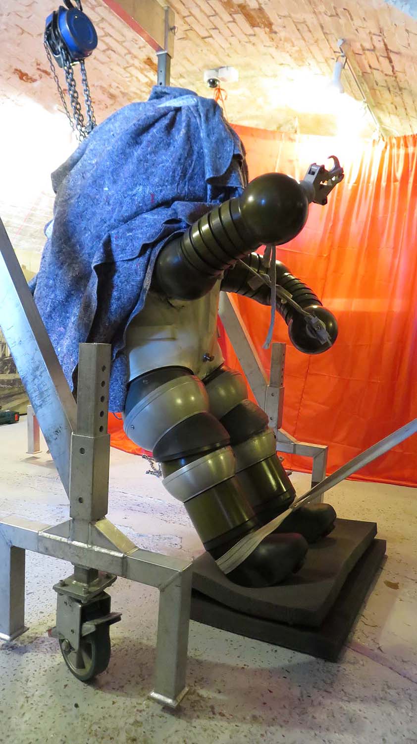 Side view of Jim being raised. In almost vertical position. Head still covered with blanket.
