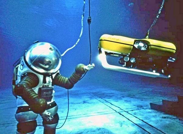 A JIM suit under water with a tethered remotely operated vehicle