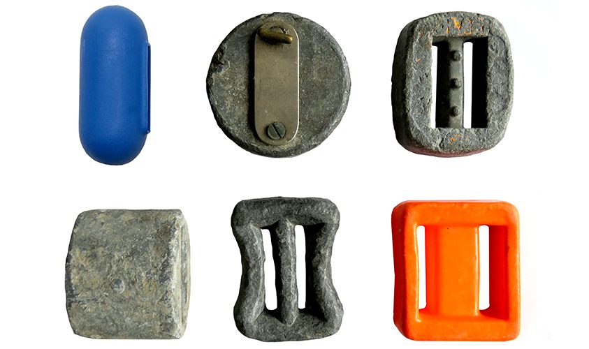 6 objects - 4 look like thick buckles, one is circular, one is capsule shaped. 4 are grey, one (capsule) is blue and one (buckle) is yellow.